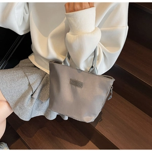 Close-up of grey lightweight casual tote bag with FASHION patch and zip closure