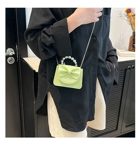 Detailed view of mini green litchi grain bag with bow decoration and pearl handle
