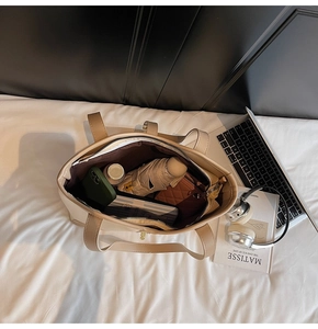 Large capacity contrast tote bag interior with multiple daily items and zipper pocket