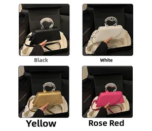 Dettaglio di borse quadrate asimmetriche in nero, bianco, oro e magenta con manici in metallo