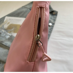 Detailed close-up of smooth pink nylon fabric with high-quality metal zipper and slider
