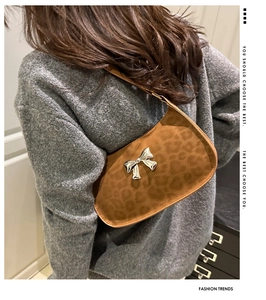 Détail du sac à bandoulière léopard avec nœud en métal argenté et texture en daim doux