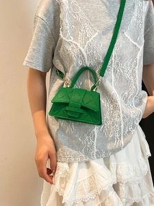 Vibrant green quilted handbag with minimalist top handle and crossbody strap for women