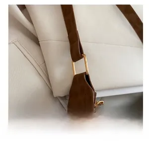 Détail du sac léopard montrant la boucle en métal doré et la connexion de la bandoulière en cuir