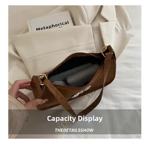 Vue détaillée de l'intérieur du sac porté épaule en daim marron et sa capacité