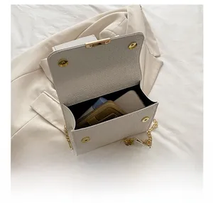 Vue intérieure d'un sac à bandoulière tressé blanc cassé avec accessoires dorés et capacité