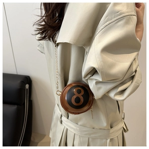 Detail of coffee brown billiard 8 ball chain crossbody bag styled with a beige coat