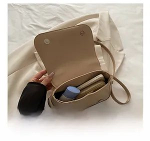Vue intérieure du sac beige montrant la capacité pour téléphone, portefeuille et cosmétiques