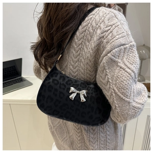 Détail du sac sous l'aisselle à imprimé léopard avec fermoir papillon argenté et daim