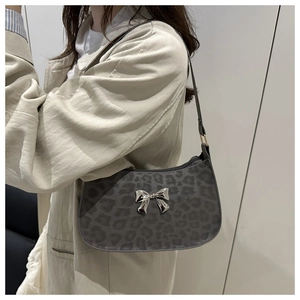 Détail du sac sous l'aisselle à imprimé léopard gris avec un nœud métallique argenté