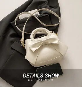 Overhead view of white crossbody bag with large bow detail and gold hardware