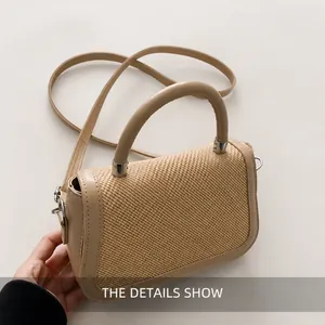 Détail du sac beige tissé avec poignée en cuir et boucles métalliques argentées