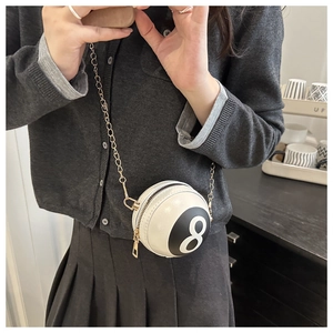 Gros plan d'un mini sac en cuir blanc en forme de boule de billard n°8 avec chaîne