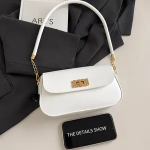 Detailed view of white crossbody bag with gold woven buckle and smartphone size comparison