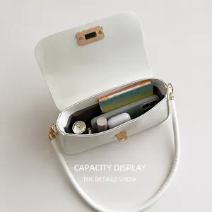 Detailed interior of a white crossbody bag showing storage space for phone and makeup