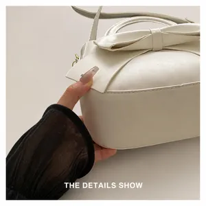 Detailed close-up showing precision stitching on the white bow-knot minimalist handbag
