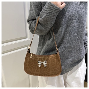 Détail du sac sous le bras à motif léopard marron avec boucle nœud en métal argenté