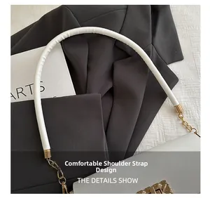 Detail of comfortable thickened white leather shoulder strap with gold metal link hardware