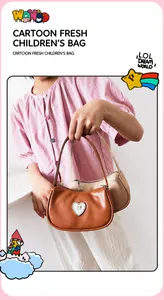 Detail der Kindertasche mit Strass-Herz und goldener Schleife auf PU-Leder-Finish