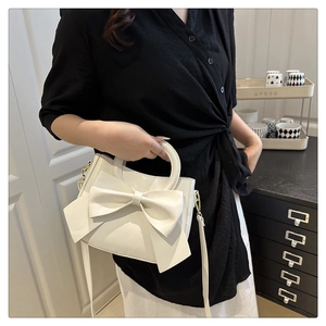 Detail of the white sweet-style tote with a large bow decoration and round handle