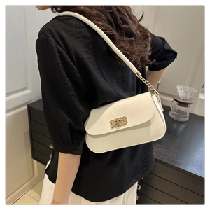 Detail of white leather shoulder bag featuring a vintage gold rectangular buckle and chain
