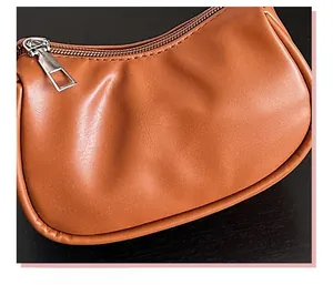 Nahaufnahme der braunen Lederhandtasche mit Plisseekonstruktion und silbernem Reißverschluss