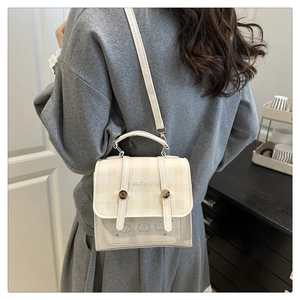 Detail of off-white checkered bag with cartoon animal prints and short handle strap