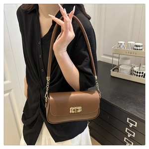 Détail du sac en cuir marron avec une boucle en métal doré et une bandoulière élégante