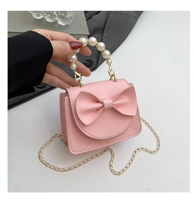 Close-up of pink mini handbag featuring a large bow and elegant pearl handle detail