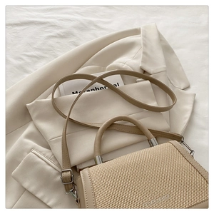 Détail du sac à main beige avec rabat texturé tissé et bandoulière en cuir lisse