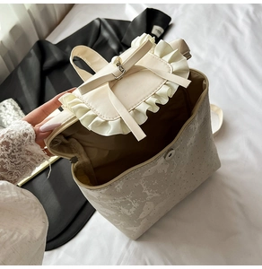 Détail du rabat à volants avec perle et nœud en soie sur sac à dos ivoire chic