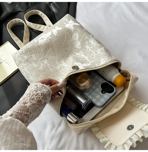 Detail view of the spacious interior of this ruffled cream backpack with butterfly accents
