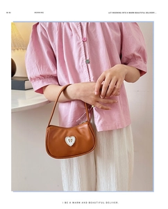 Braune Hobo-Schultertasche mit weißem Herzanhänger und goldener Schleife für Damen