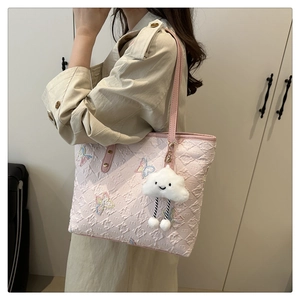 Detail of pink embroidered tote bag with 3D texture and cute plush cloud charm
