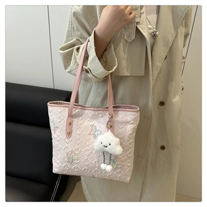 Detail of light pink tote bag with floral butterfly embroidery and quilted pattern