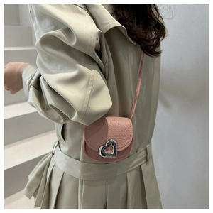 Detailed macro view of a pink lychee leather mini crossbody bag with a silver heart buckle
