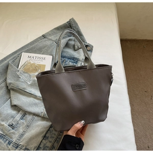 Close-up of taupe nylon mini tote bag with FASHION patch and soft gray fabric handles