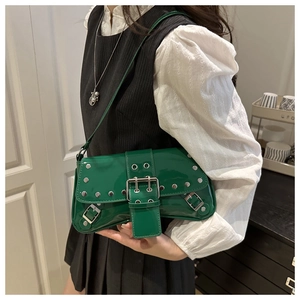 Detail of green patent leather shoulder bag with punk silver rivets and metal buckle design