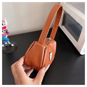 Detail view of caramel brown square tote with silver heart hardware and top handle