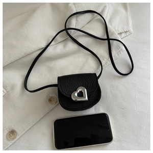 Close-up of mini black pebble leather crossbody bag with silver heart metal buckle