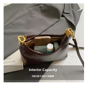 Detail view of the open dark red leather crossbody bag showing its interior capacity