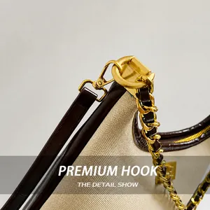 Detail of premium gold metal clasp and chain strap on a canvas crossbody dumpling bag