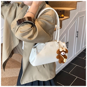 Witte glanzende lederen schoudertas met een schattige bruine teddybeer sleutelhanger