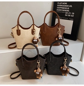 Quattro borse a secchiello vintage nei colori beige, marrone, caffè e nero con ciondoli