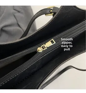 Détail d'une fermeture éclair dorée fluide sur un grand sac cabas vintage noir