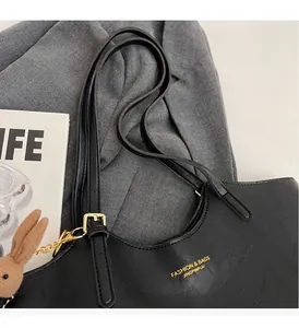 Détails du sac fourre-tout noir en cuir texturé avec un charmant lapin en tricot attaché
