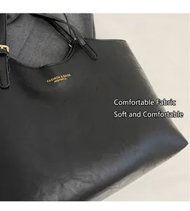 Détail de la texture cuir mat et lettrage doré sur un grand sac cabas noir