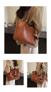 Détail d'un grand sac cabas vintage en cuir marron avec lettrage doré et bijou lapin