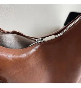 Gros plan détaillé d'un sac en cuir marron avec fermeture éclair en métal argenté chic