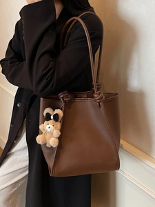 Brown leather tote bag for women with knotted strap and cute plush bear charm decoration